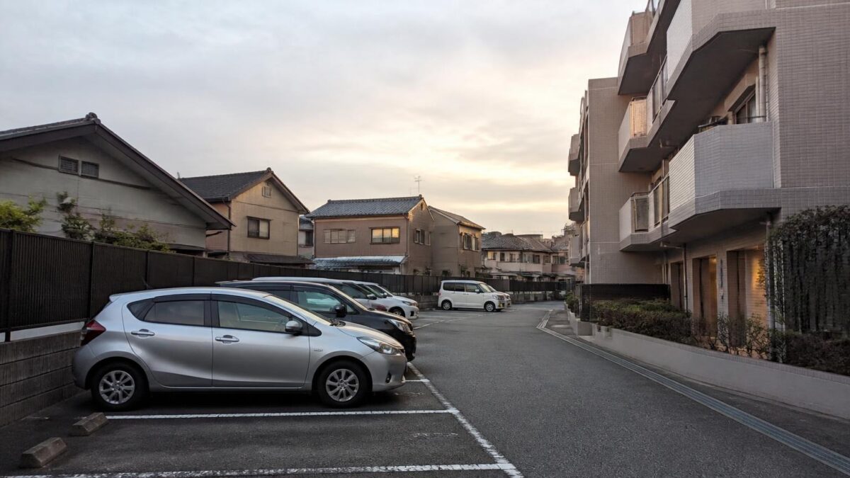 月極駐車場に停めた車と住宅街の外観