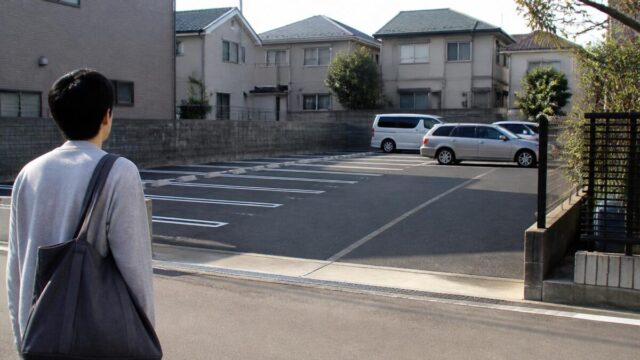 新居近くの月極駐車場を確認する日本の住宅街の風景