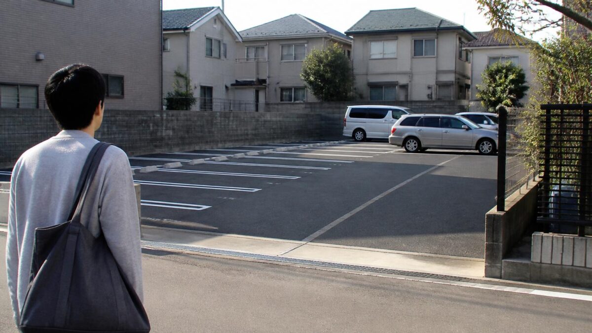 新居近くの月極駐車場を確認する日本の住宅街の風景